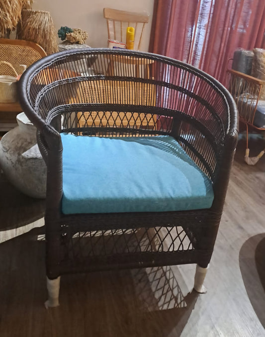 Rattan armchair with velvet cushion in boho style